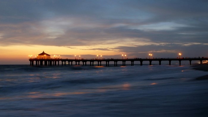 Pier at sunset over the ocean with waves