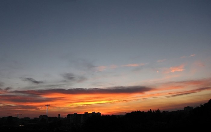 Sunset over city skyline with colorful clouds