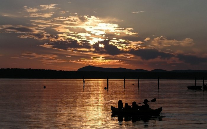 Canoe on a lake at sunset with mountains