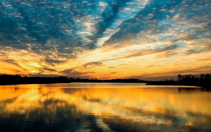 Sunset over a calm lake with colorful clouds