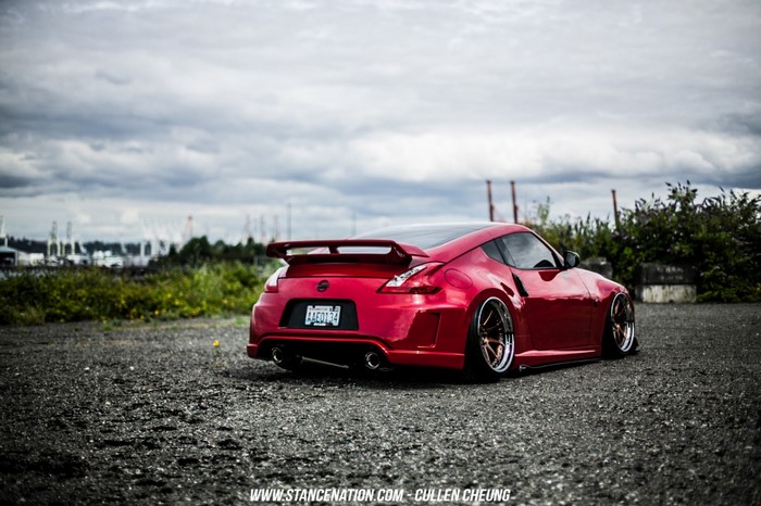 Red Nissan 370Z sports car parked on gravel