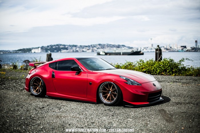 Red Nissan 370Z sports car on gravel by the water