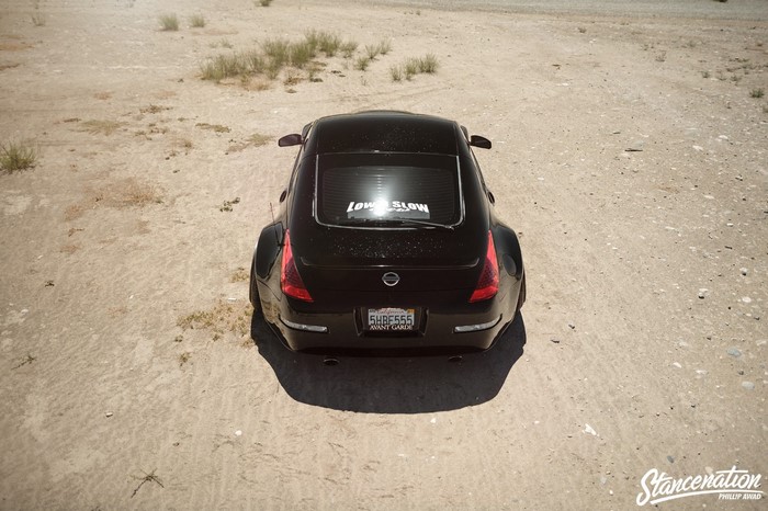Black Nissan 350Z with "LOW SLOW" sticker in desert