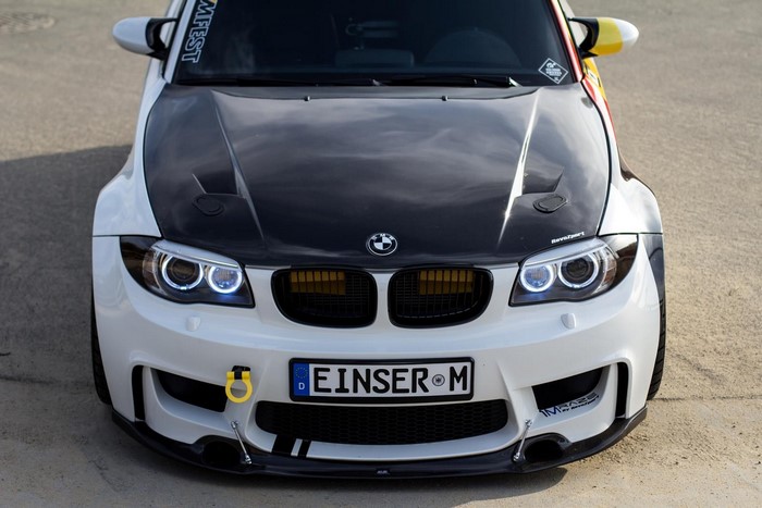 White BMW 1 Series with black hood and yellow tow hook