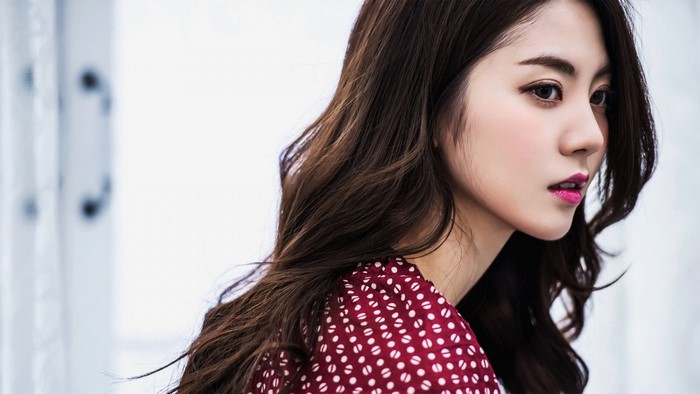 Asian woman with long brown hair and red polka dot dress