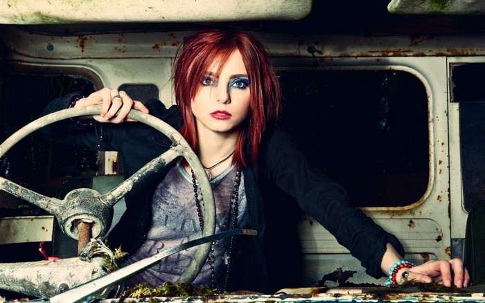 Woman with red hair in a derelict vehicle