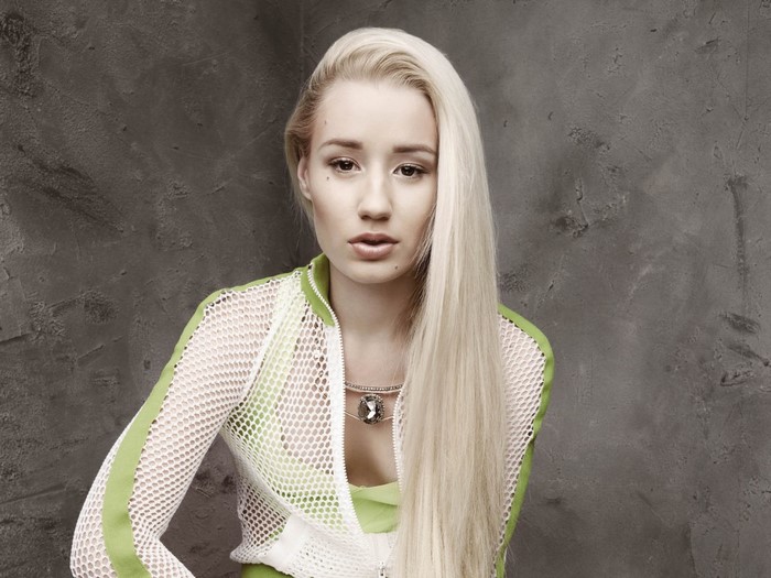 Iggy Azalea posing in a green and white outfit
