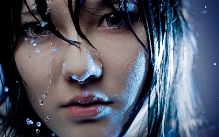 Close-up portrait of a woman with wet hair and water drops
