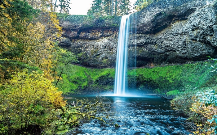 Waterfall cascading over a rocky cliff into a river