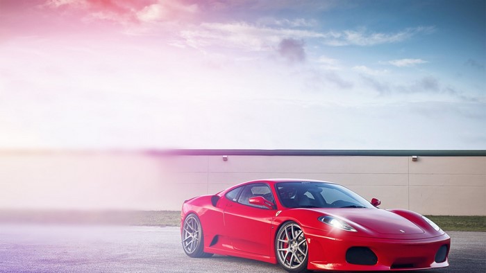 Red Ferrari F430 parked in front of a building