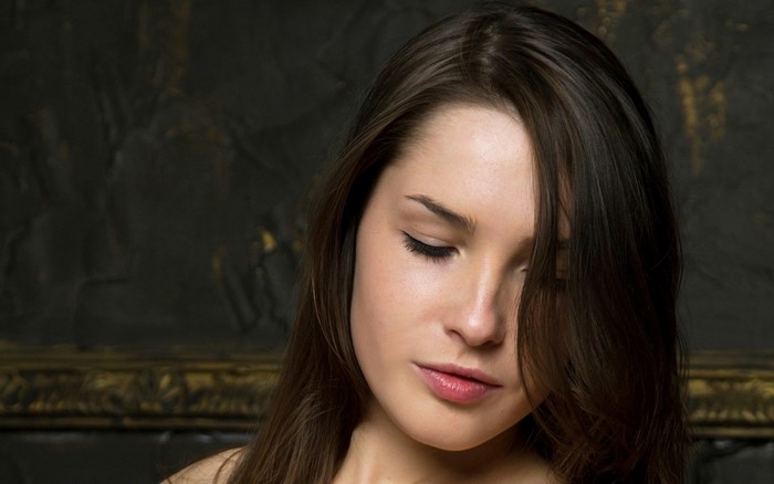 Woman with long brown hair looking down