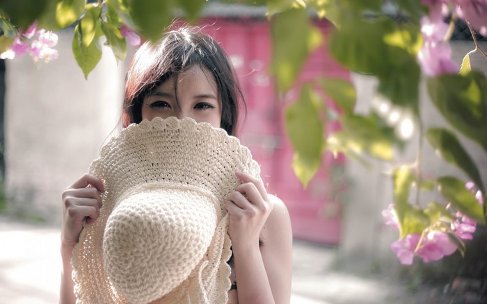 Woman hiding face with a straw hat