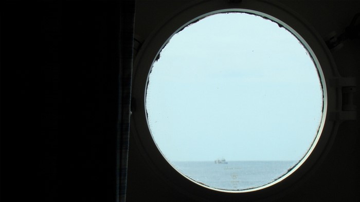 Porthole view of a ship on the sea