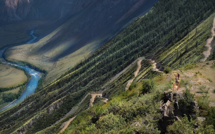 Woman on a mountain ridge overlooking a river valley