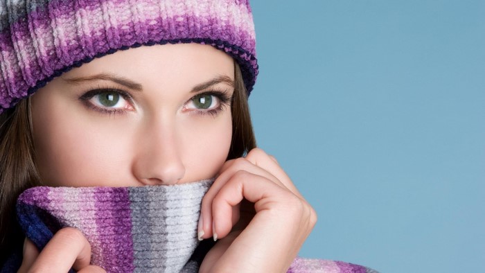 Woman wearing a purple and pink striped hat and scarf