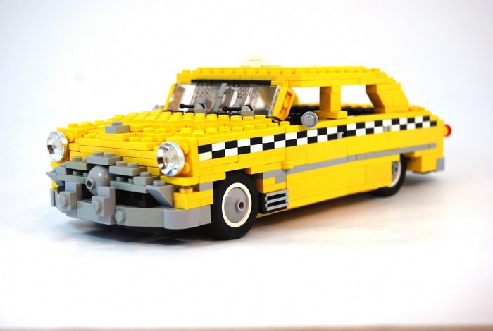 Yellow LEGO taxi model with checkered stripe