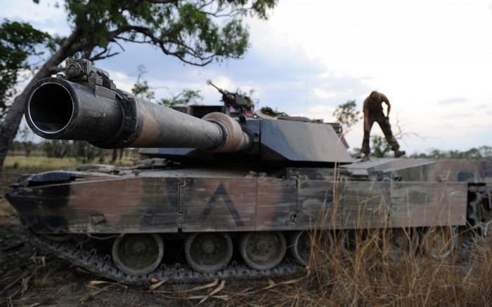 Soldier on an M1 Abrams tank in a field