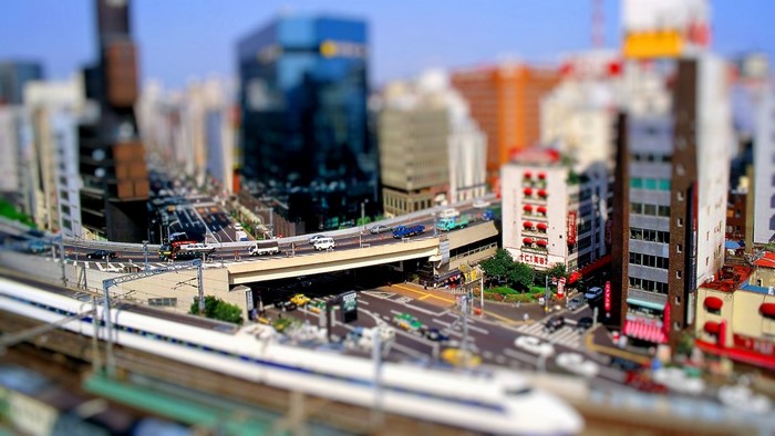Tilt-shift cityscape with train and traffic