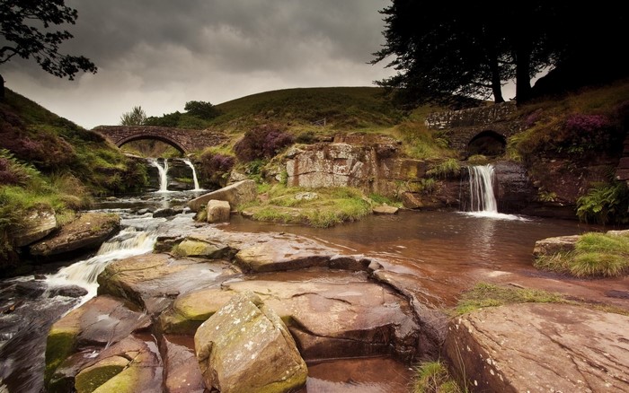 Stone bridges over a rocky stream with waterfalls