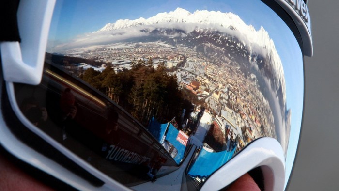 Ski goggles reflecting a snowy mountain town