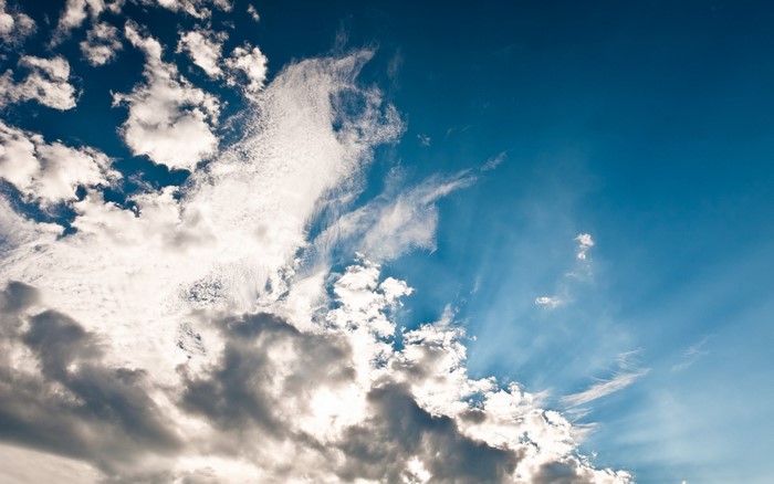 Sunlight filtering through clouds in a blue sky
