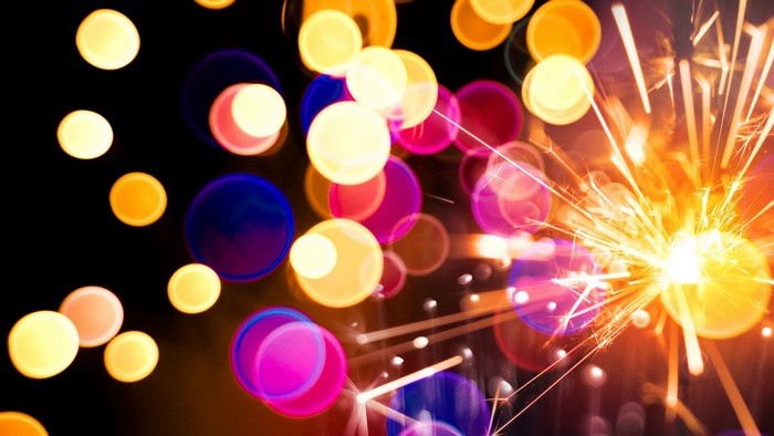 Bokeh circles and sparks from a sparkler at night