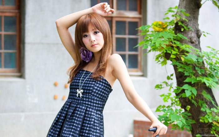Asian woman with long brown hair wearing a blue dress