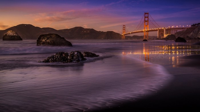 Golden Gate Bridge at dusk with ocean waves