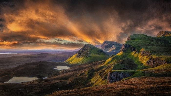 Dramatic sunset over green hills and lochs