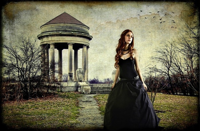 Woman in black dress near ancient structure