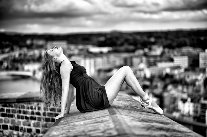 Woman in black dress and ballet shoes on a rooftop