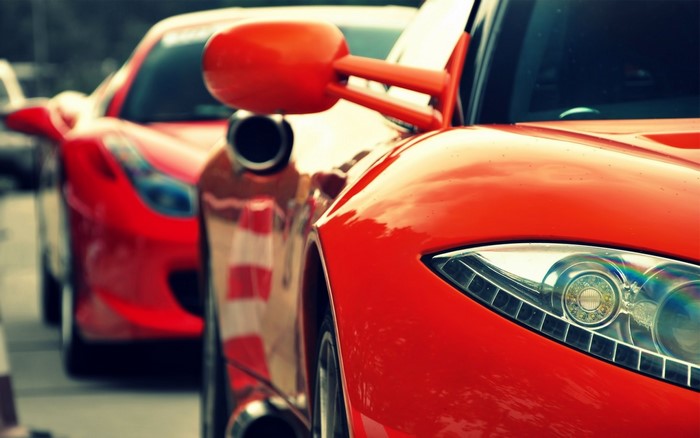 Two red sports cars, one in the foreground