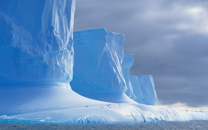 Giant icebergs in the Arctic Ocean under a cloudy sky
