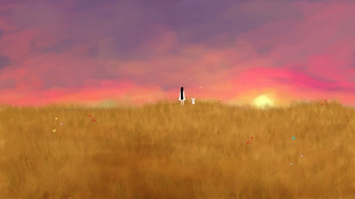 Girl and rabbit in a field at sunset