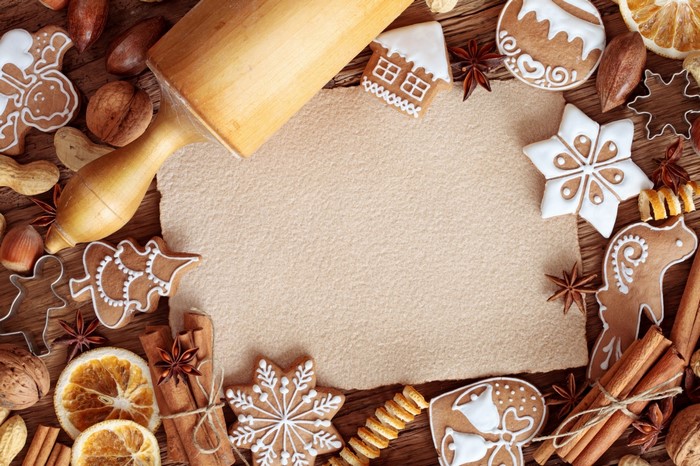 Christmas gingerbread cookies and baking ingredients on a wooden table