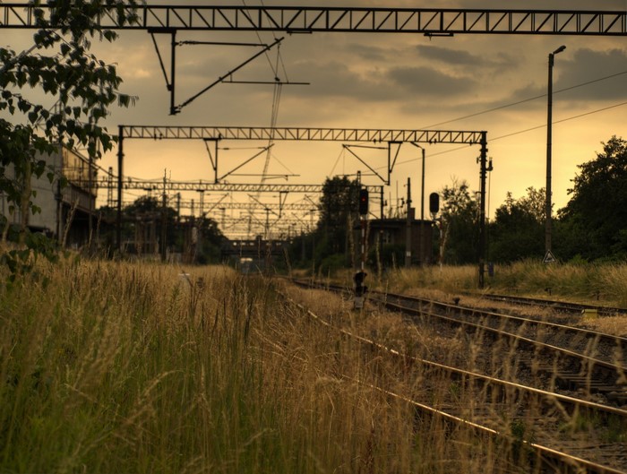 Train tracks and overhead power lines at dusk