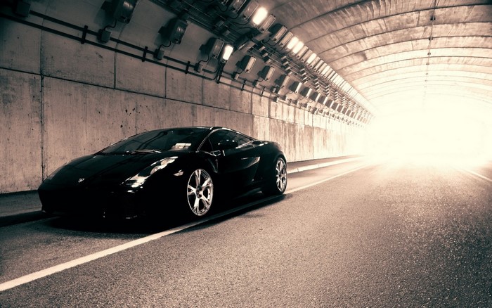 Black Lamborghini sports car in a concrete tunnel