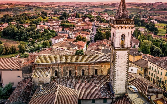 Aerial view of a historic Italian town with a church tower