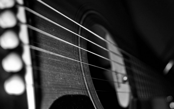 Close-up of an acoustic guitar's strings and tuning pegs