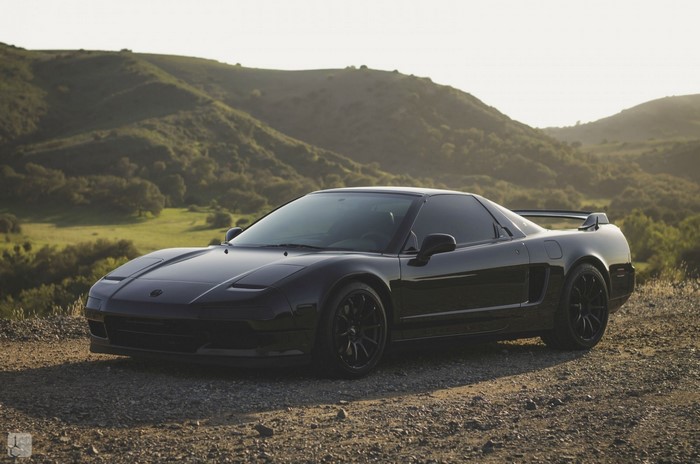 Black Acura NSX parked on a dirt road with hills