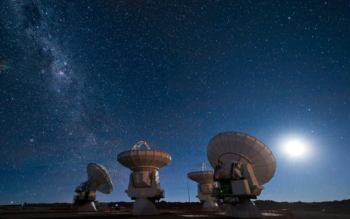 Radio telescopes under a starry night sky