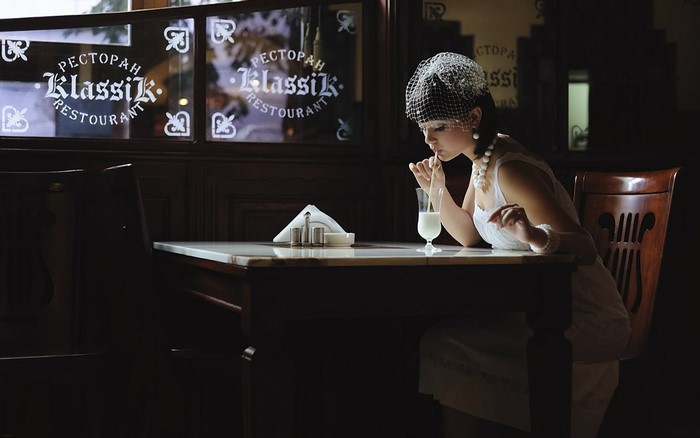 Woman in vintage attire drinking from a glass