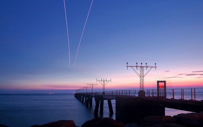 Airport landing lights pier at sunset over the sea