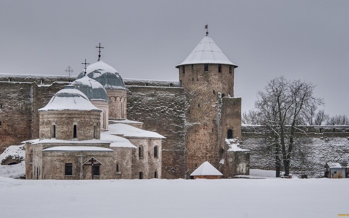 Snowy winter scene of a stone castle with churches and a tower