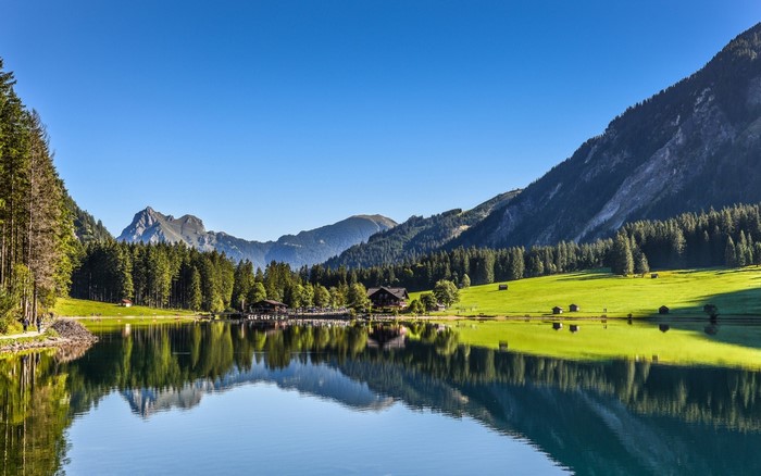 Lake reflection of mountains and forest in the Alps