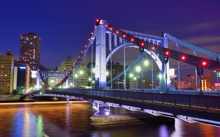 Illuminated City Bridge at Night with Reflections