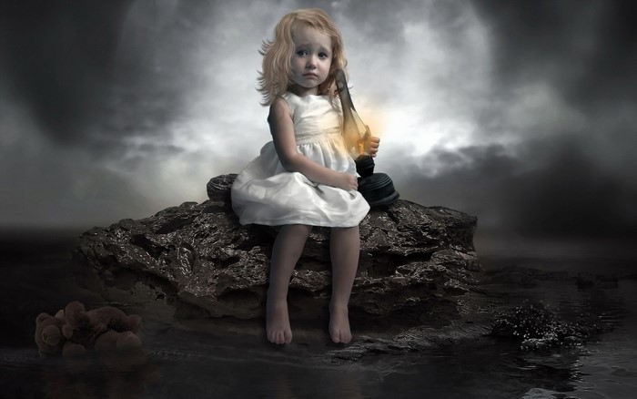 A young girl holding a lantern on a rock