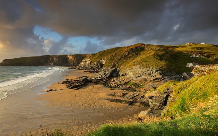 Coastal landscape with cliffs, beach, and houses