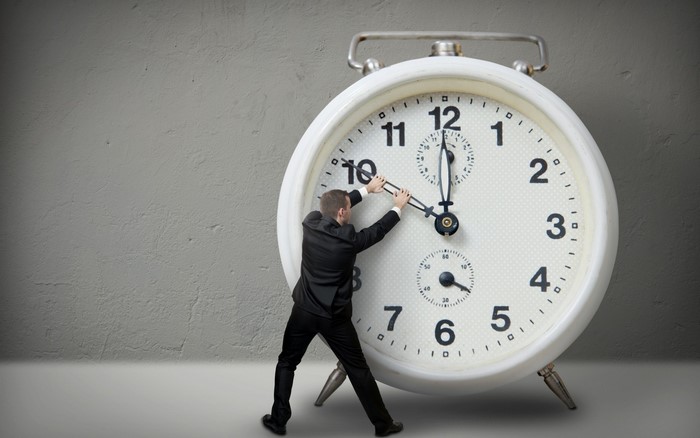 Man adjusting hands on a large alarm clock