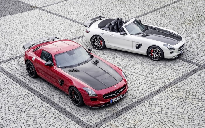 Two Mercedes-Benz SLS AMG sports cars on cobblestone